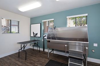 A room with a table and chairs and a stainless steel sink.